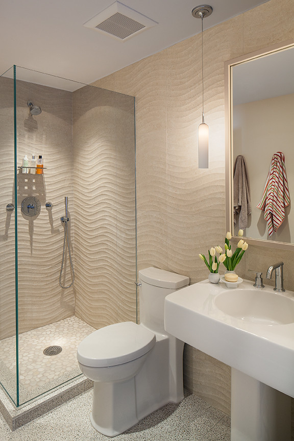 Mid-sized beach style 3/4 beige tile and ceramic tile pebble tile floor corner shower photo in New York with a pedestal sink, a one-piece toilet and beige walls