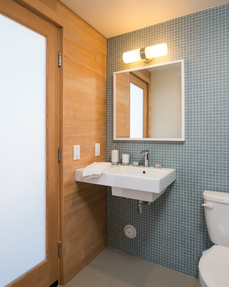 Cette image montre une petite salle de bain design pour enfant avec un lavabo suspendu, mosaïque, un mur bleu et un sol en calcaire.