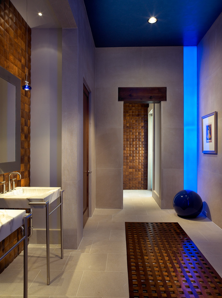 Immagine di una stanza da bagno design con lavabo a consolle e piastrelle effetto legno