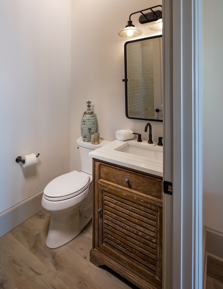 This is an example of a small classic shower room bathroom in Atlanta with distressed cabinets, a one-piece toilet, light hardwood flooring, a submerged sink, brown floors, a hinged door, white worktops, louvered cabinets, beige tiles, white walls, porcelain tiles, engineered stone worktops, a wall niche, a single sink and a freestanding vanity unit.