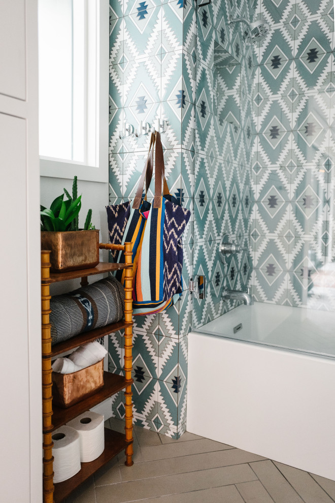 Design ideas for a medium sized eclectic family bathroom in Austin with white cabinets, an alcove bath, a shower/bath combination, blue tiles, ceramic tiles, blue walls, grey floors, white worktops and a hinged door.
