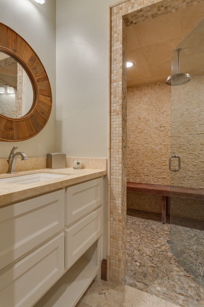 Foto på ett stort vintage badrum, med öppna hyllor, vita skåp, en toalettstol med hel cisternkåpa, beige kakel, stenkakel, vita väggar, travertin golv, ett undermonterad handfat, granitbänkskiva, beiget golv, dusch med gångjärnsdörr och en kantlös dusch