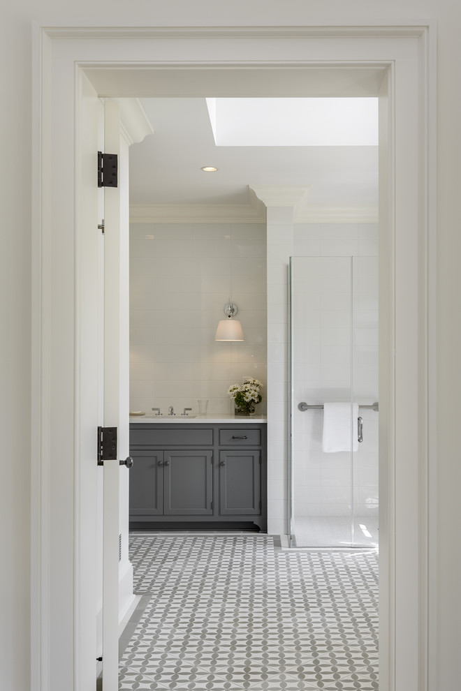 Exemple d'une salle de bain grise et blanche nature avec un placard avec porte à panneau encastré, des portes de placard grises, une douche à l'italienne, un carrelage blanc, un sol en carrelage de terre cuite et un sol multicolore.