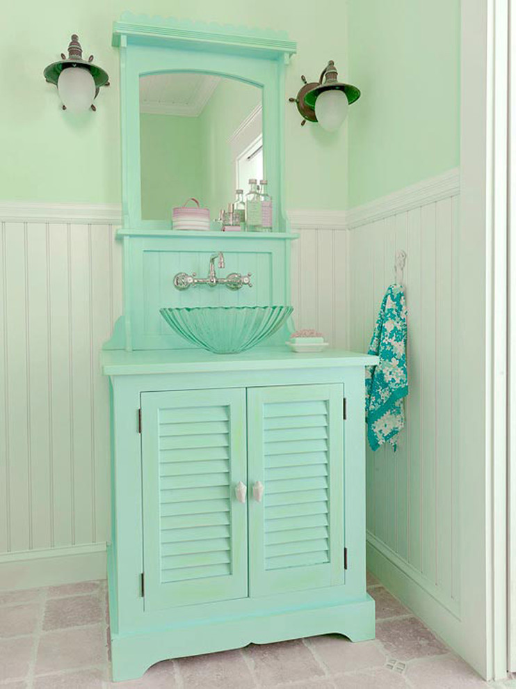 Foto di una stanza da bagno tropicale con consolle stile comò, ante con finitura invecchiata, top in legno e piastrelle beige