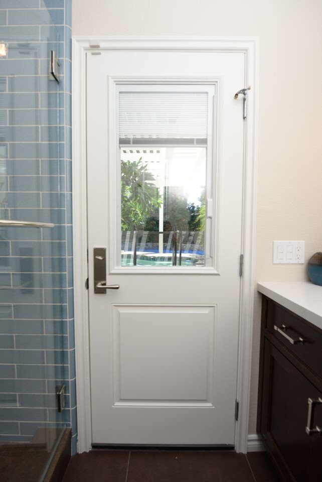 Inredning av ett modernt litet badrum med dusch, med ett undermonterad handfat, luckor med infälld panel, skåp i mörkt trä, bänkskiva i kvarts, en hörndusch, en toalettstol med hel cisternkåpa, blå kakel, glasskiva, beige väggar och klinkergolv i keramik
