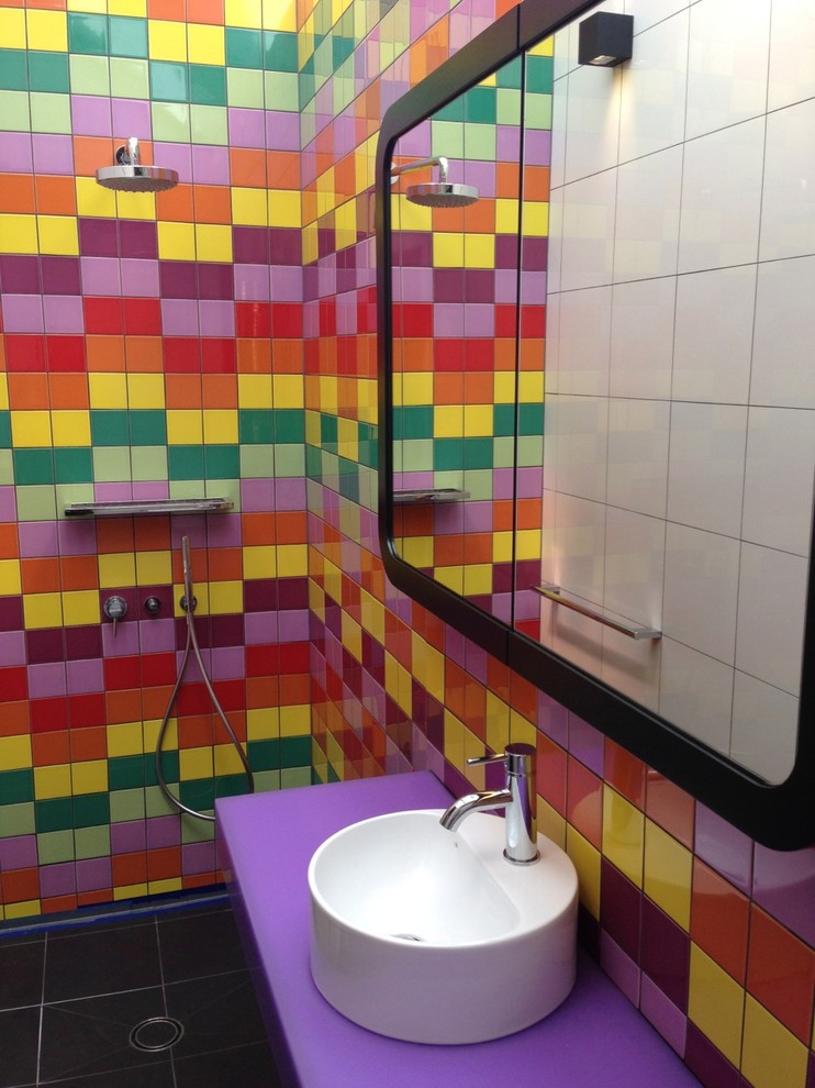 Modern inredning av ett litet badrum, med ett fristående handfat, bänkskiva i akrylsten, en hörndusch, en vägghängd toalettstol, keramikplattor och klinkergolv i porslin