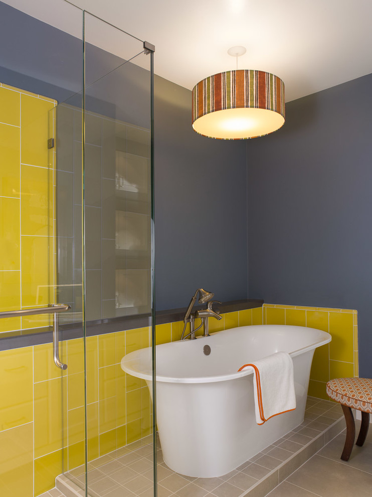 На фото: главная ванная комната среднего размера в современном стиле с белыми фасадами, столешницей из искусственного кварца, отдельно стоящей ванной, желтой плиткой, стеклянной плиткой, синими стенами и полом из керамогранита
