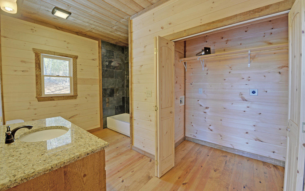Medium sized rustic shower room bathroom in Atlanta with raised-panel cabinets, medium wood cabinets, a two-piece toilet, black tiles, slate tiles, white walls, a submerged sink, granite worktops, brown floors, an open shower, a double shower and concrete flooring.