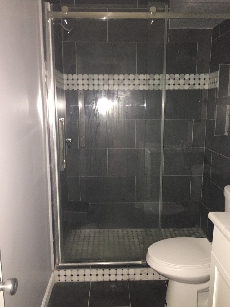 Inspiration for a mid-sized transitional 3/4 black tile and stone tile slate floor alcove shower remodel in New York with a two-piece toilet and gray walls