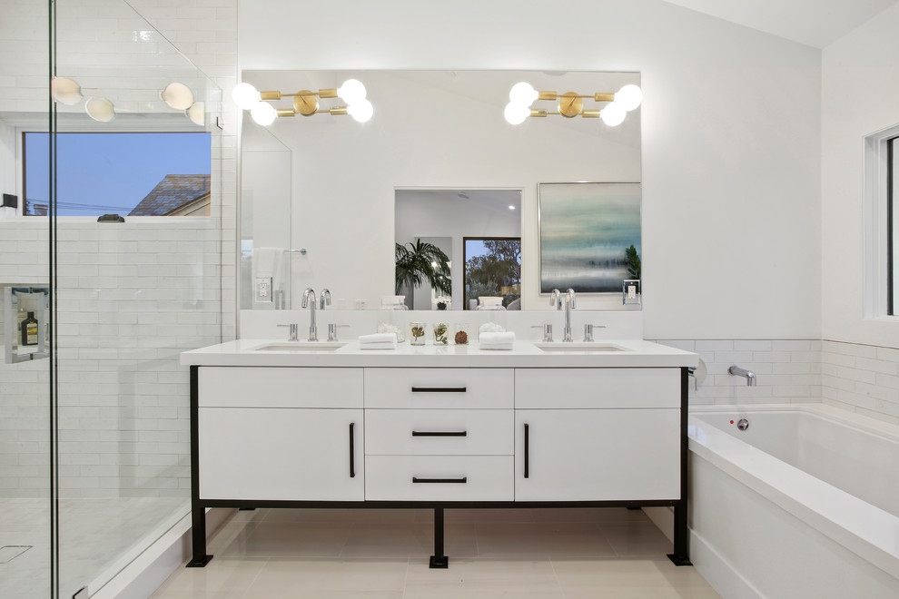 Cette image montre une douche en alcôve design avec un placard à porte plane, des portes de placard blanches, un mur blanc, un sol en carrelage de porcelaine, un sol beige, une cabine de douche à porte battante, un plan de toilette blanc, une baignoire encastrée et un lavabo encastré.