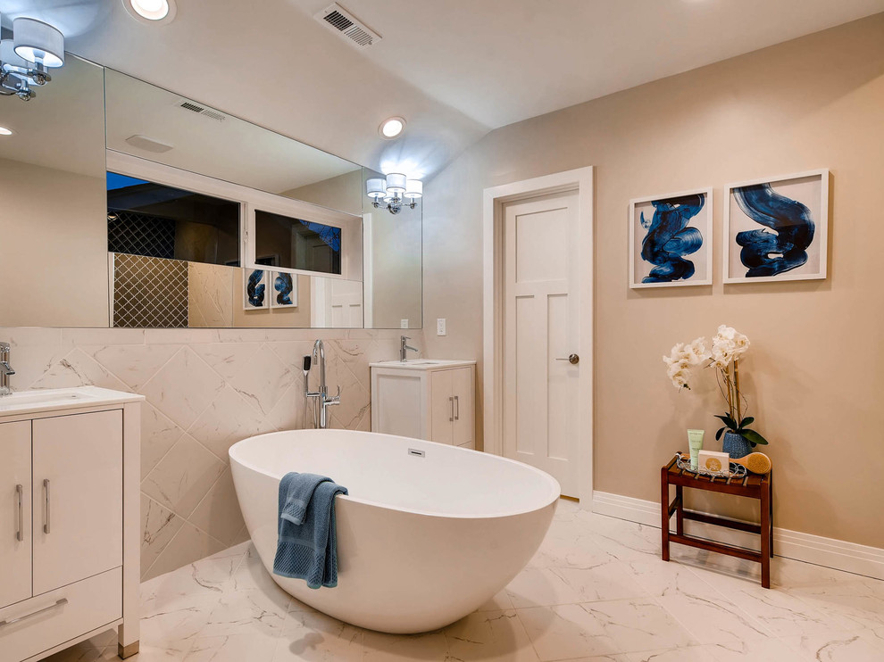 Large transitional master white tile and stone tile marble floor and white floor freestanding bathtub photo in Denver with flat-panel cabinets, white cabinets, beige walls and an undermount sink