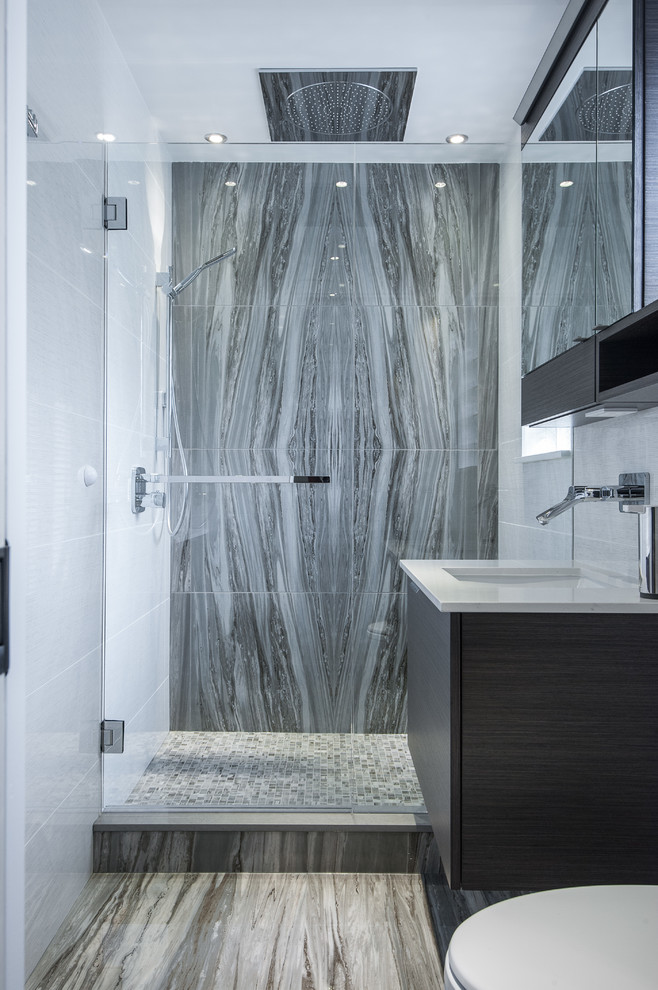This is an example of a contemporary bathroom in Vancouver with a submerged sink, flat-panel cabinets, black cabinets, an alcove shower, grey tiles and stone slabs.