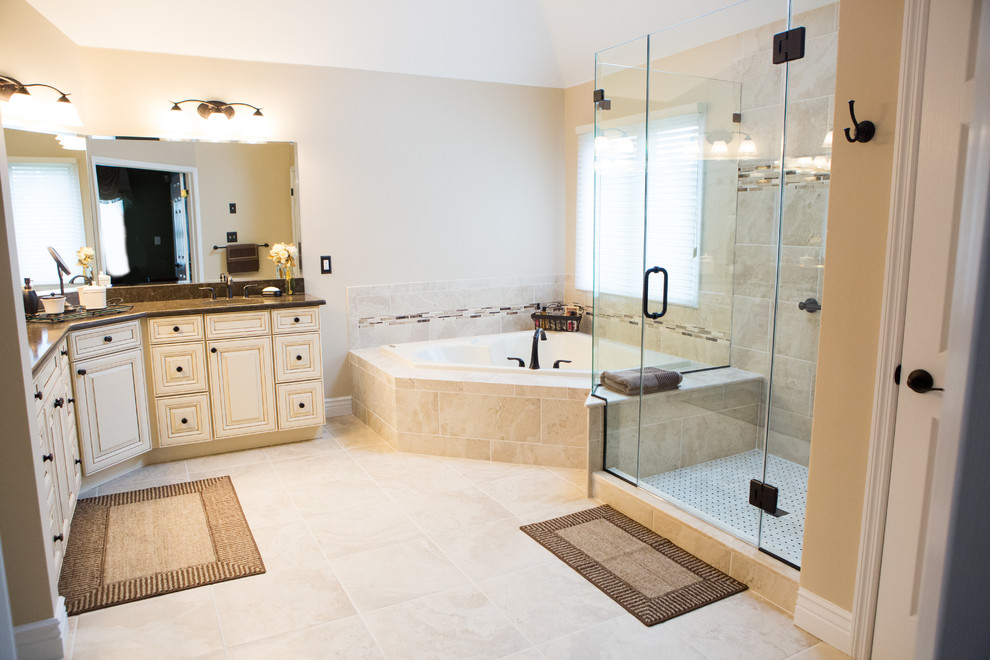Inspiration for a large timeless master beige tile and porcelain tile porcelain tile bathroom remodel in New York with raised-panel cabinets, distressed cabinets, a two-piece toilet, beige walls, an undermount sink and quartz countertops