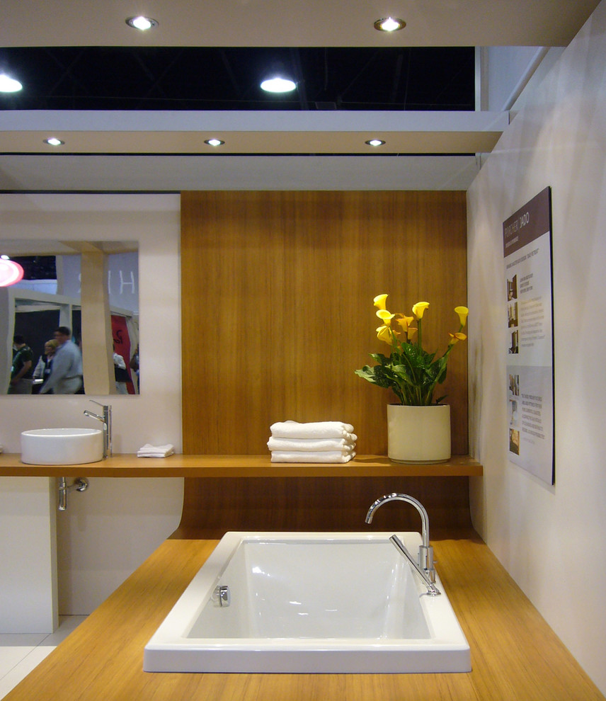 Immagine di una stanza da bagno padronale minimalista con lavabo a bacinella, top in legno, vasca da incasso, doccia aperta, WC monopezzo e pareti bianche