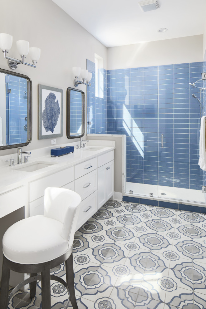 Inredning av ett maritimt mellanstort vit vitt en-suite badrum, med skåp i shakerstil, vita skåp, en dusch i en alkov, blå kakel, keramikplattor, grå väggar, cementgolv, ett undermonterad handfat, bänkskiva i kvarts, flerfärgat golv och dusch med gångjärnsdörr