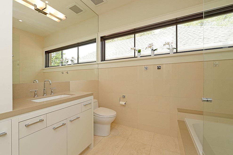 Cette photo montre une salle d'eau moderne de taille moyenne avec un lavabo posé, un placard à porte plane, des portes de placard blanches, une baignoire posée, un combiné douche/baignoire, WC à poser, un carrelage beige, un mur beige, des carreaux de porcelaine, un sol en carrelage de porcelaine et un plan de toilette en quartz.