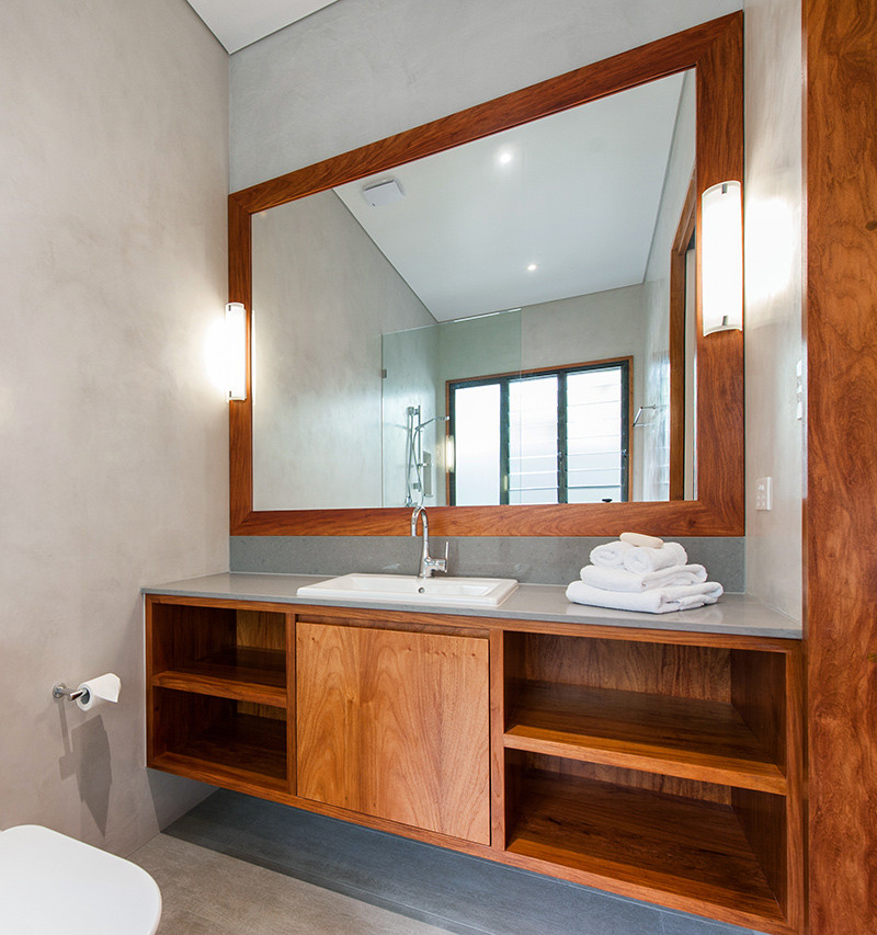 Cette photo montre une salle de bain exotique en bois brun de taille moyenne avec un lavabo posé, un placard en trompe-l'oeil, un plan de toilette en quartz modifié, une douche ouverte, WC à poser, un carrelage gris, un mur gris et un sol en carrelage de céramique.