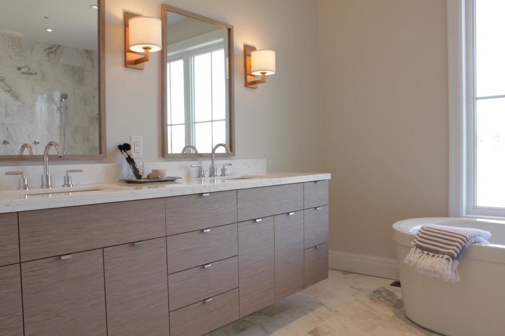 Idées déco pour une grande salle de bain principale contemporaine en bois clair avec un placard à porte plane, une baignoire indépendante, un mur gris, un sol en marbre, un lavabo encastré et un plan de toilette en quartz.
