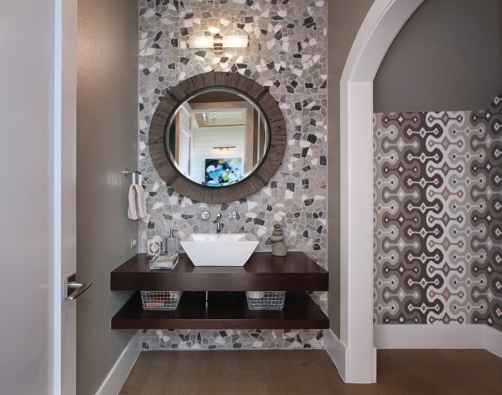 Cette image montre une salle de bain design avec une vasque, un plan de toilette en bois, un carrelage multicolore, un mur gris et parquet foncé.