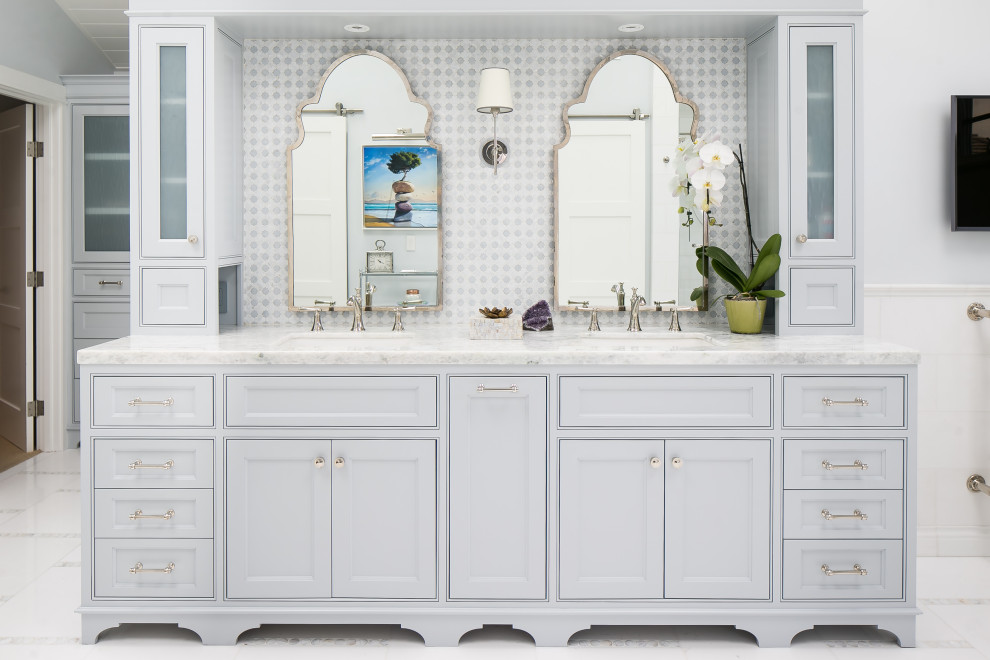 Cette image montre une salle de bain principale marine avec un placard à porte affleurante, des portes de placard grises, un carrelage multicolore, un mur gris, un lavabo encastré, un sol blanc et un plan de toilette blanc.