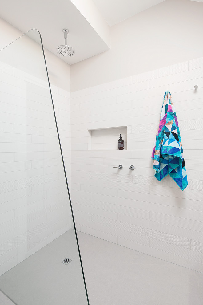 Idee per una piccola stanza da bagno con doccia minimal con ante di vetro, ante bianche, doccia aperta, piastrelle bianche, lavabo a bacinella, top in laminato e doccia aperta