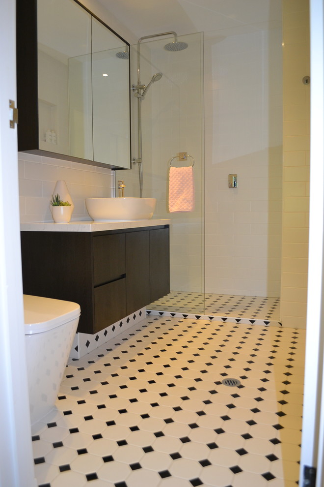 メルボルンにある高級な小さなトラディショナルスタイルのおしゃれなマスターバスルーム (フラットパネル扉のキャビネット、黒いキャビネット、オープン型シャワー、一体型トイレ	、白いタイル、サブウェイタイル、白い壁、セラミックタイルの床、ベッセル式洗面器、テラゾーの洗面台、白い床、オープンシャワー) の写真
