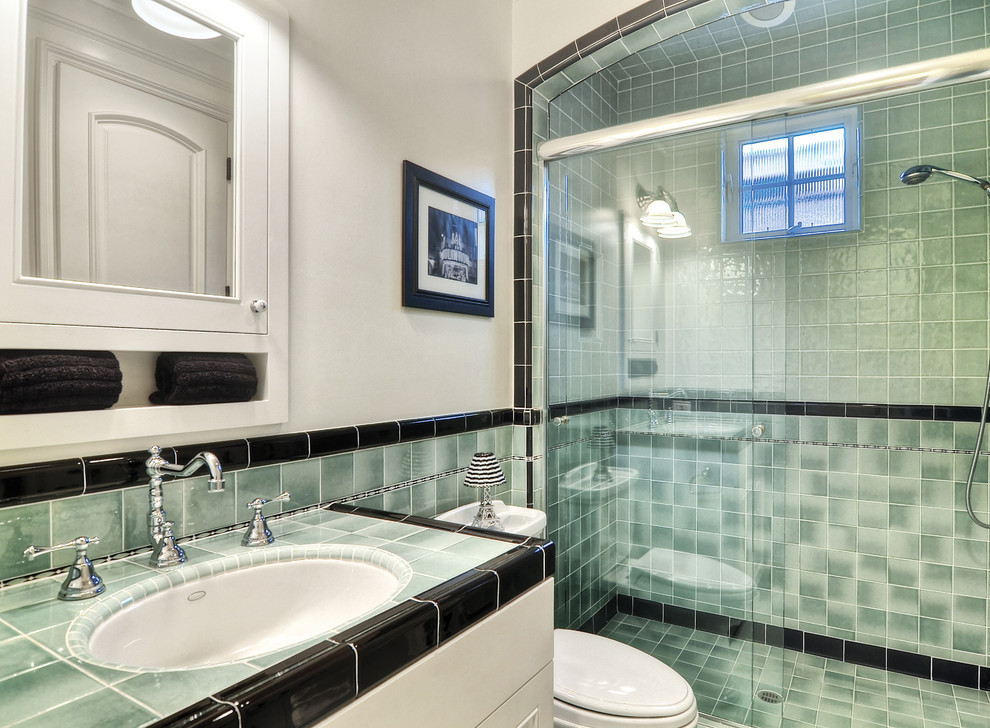 Cette photo montre une salle de bain chic avec des portes de placard blanches, WC séparés, un carrelage multicolore, des carreaux de céramique, un mur vert, un lavabo encastré, un plan de toilette en carrelage et une cabine de douche à porte coulissante.
