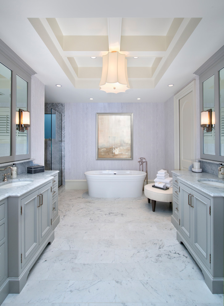 Стильный дизайн: главная ванная комната в классическом стиле с фасадами с утопленной филенкой, серыми фасадами, отдельно стоящей ванной, серыми стенами, врезной раковиной, белым полом, душем с распашными дверями и зеркалом с подсветкой - последний тренд