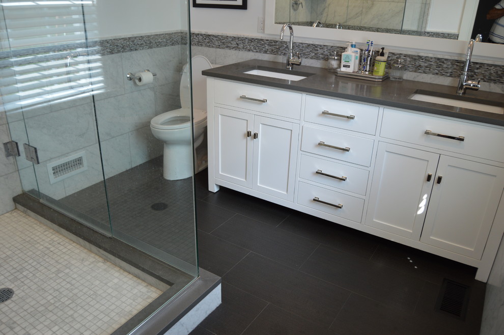 Photo of a traditional ensuite bathroom in New York with a submerged sink, recessed-panel cabinets, white cabinets, grey walls, ceramic flooring, black tiles and stone tiles.