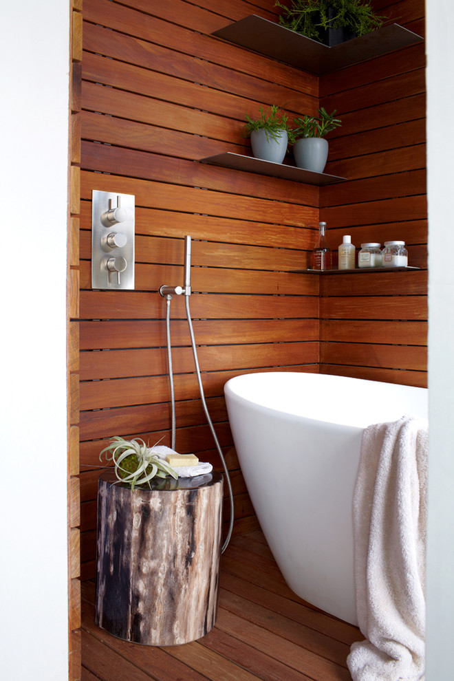 Large minimalist master medium tone wood floor freestanding bathtub photo in New York