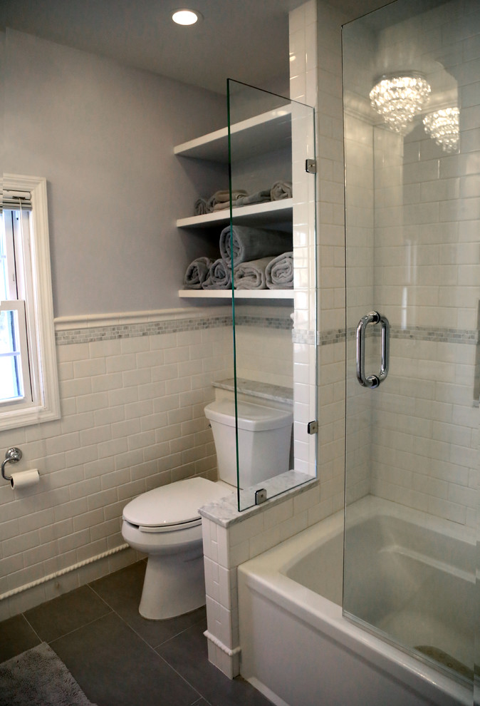 Foto på ett mellanstort vintage en-suite badrum, med möbel-liknande, vita skåp, ett badkar i en alkov, en toalettstol med separat cisternkåpa, vit kakel, keramikplattor, grå väggar, klinkergolv i porslin, ett undermonterad handfat och marmorbänkskiva