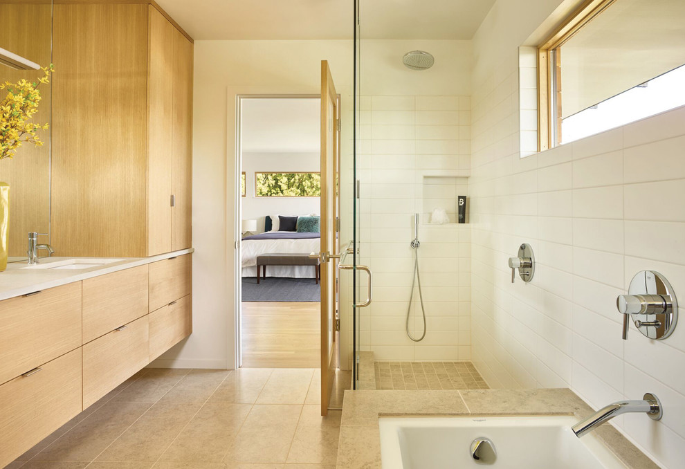 Свежая идея для дизайна: главная ванная комната в скандинавском стиле с плоскими фасадами, светлыми деревянными фасадами, полновстраиваемой ванной, белой плиткой, белыми стенами, врезной раковиной, бежевым полом и бежевой столешницей - отличное фото интерьера