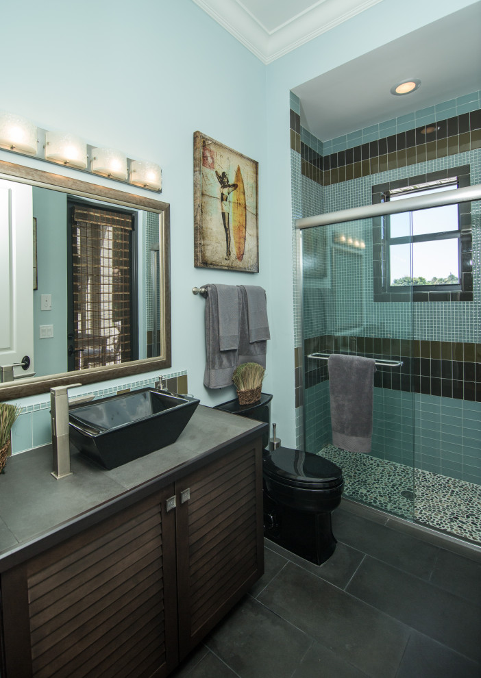 Bild på ett funkis grå grått badrum, med luckor med lamellpanel, skåp i mörkt trä, en dusch i en alkov, blå väggar, ett fristående handfat, kaklad bänkskiva och grått golv