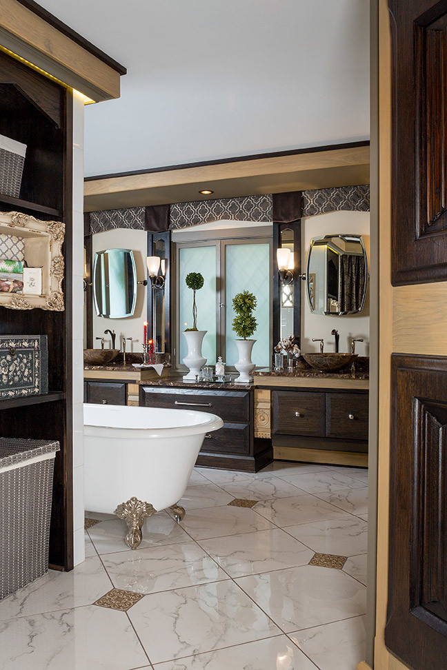 Photo of a large classic ensuite bathroom in Columbus with a vessel sink, freestanding cabinets, dark wood cabinets, marble worktops, a claw-foot bath, porcelain tiles, brown walls and porcelain flooring.
