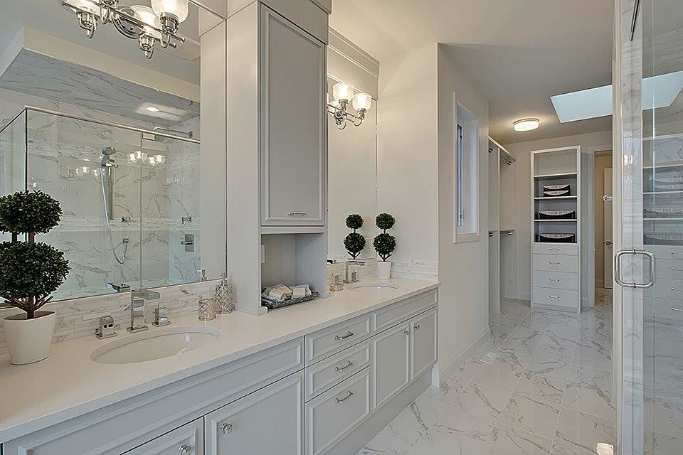Exempel på ett stort klassiskt en-suite badrum, med luckor med infälld panel, vita skåp, en hörndusch, vit kakel, marmorkakel, vita väggar, marmorgolv, ett undermonterad handfat, bänkskiva i akrylsten, vitt golv och dusch med gångjärnsdörr