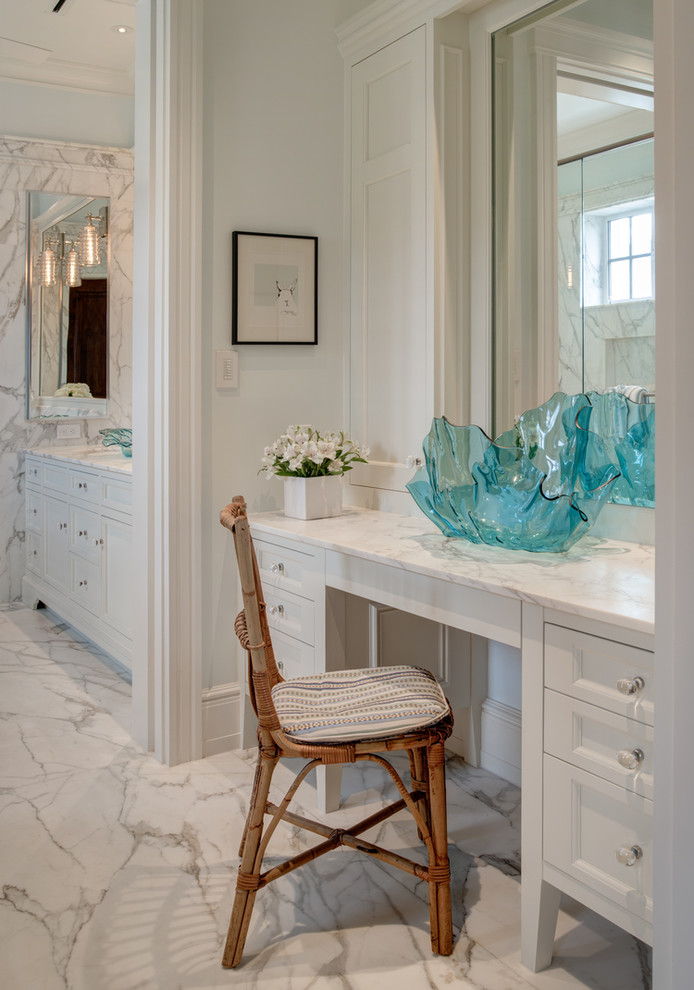 Inredning av ett stort en-suite badrum, med möbel-liknande, vita skåp, ett fristående badkar, en dubbeldusch, en toalettstol med hel cisternkåpa, vit kakel, stenhäll, blå väggar, marmorgolv, ett undermonterad handfat, marmorbänkskiva, vitt golv och dusch med gångjärnsdörr