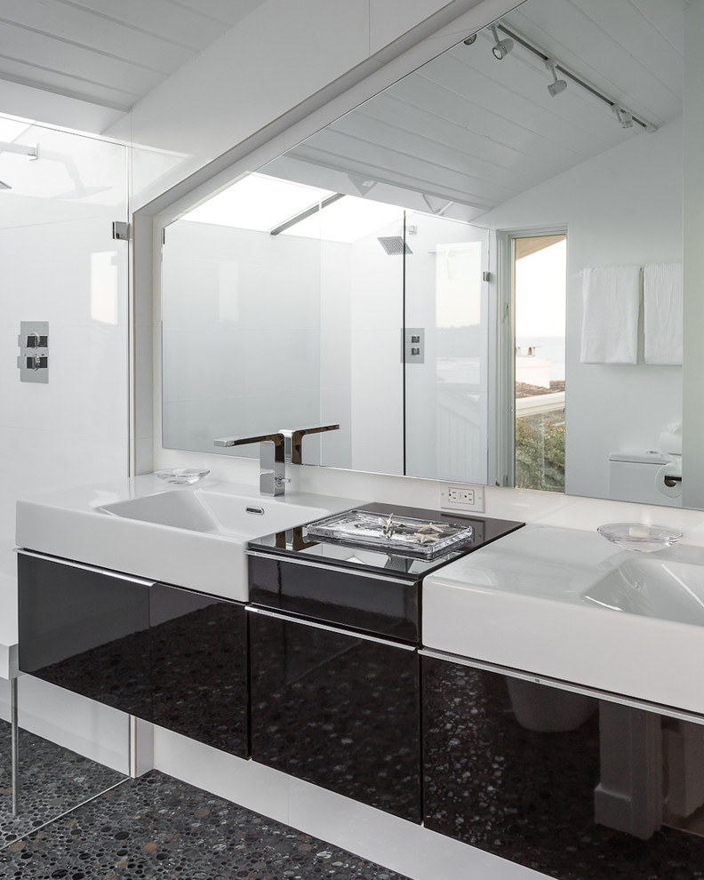 Corner shower - mid-sized modern master white tile pebble tile floor corner shower idea in San Francisco with flat-panel cabinets, black cabinets, white walls and an integrated sink