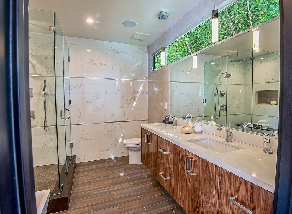 Mid-sized trendy master white tile and porcelain tile ceramic tile bathroom photo in Los Angeles with an undermount sink, flat-panel cabinets, medium tone wood cabinets, quartz countertops, a one-piece toilet and gray walls