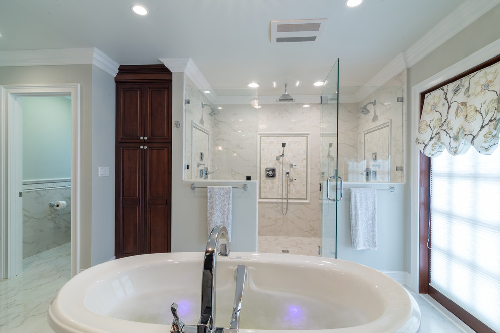 Foto på ett stort vintage en-suite badrum, med ett undermonterad handfat, luckor med upphöjd panel, skåp i mörkt trä, marmorbänkskiva, ett fristående badkar, en dubbeldusch, vit kakel och grå väggar