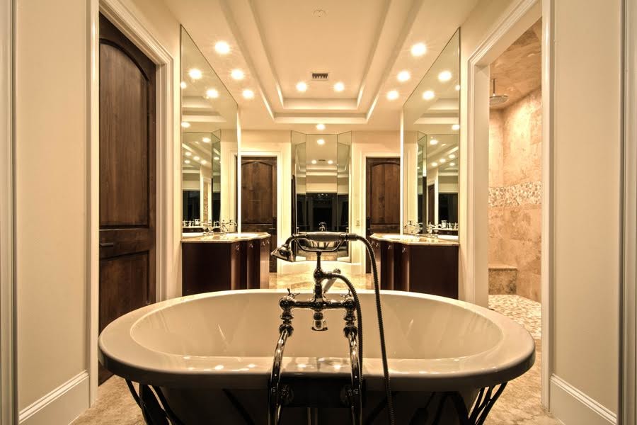 Inspiration for a medium sized contemporary ensuite bathroom in Orlando with flat-panel cabinets, dark wood cabinets, a freestanding bath, beige walls, travertine flooring, a built-in sink, granite worktops, a walk-in shower and stone tiles.