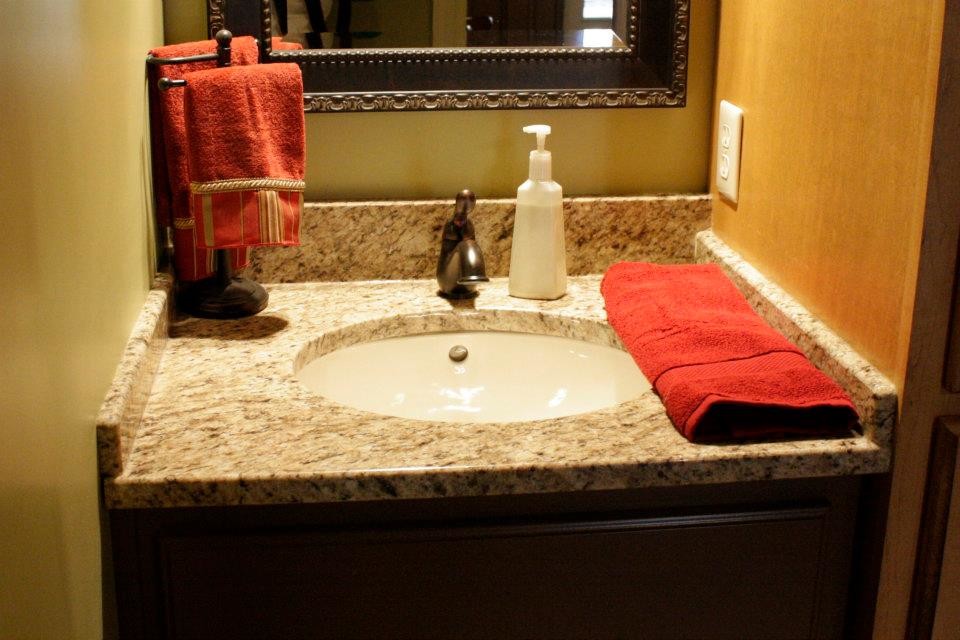 Immagine di una stanza da bagno chic con lavabo sottopiano, top in granito e pareti beige