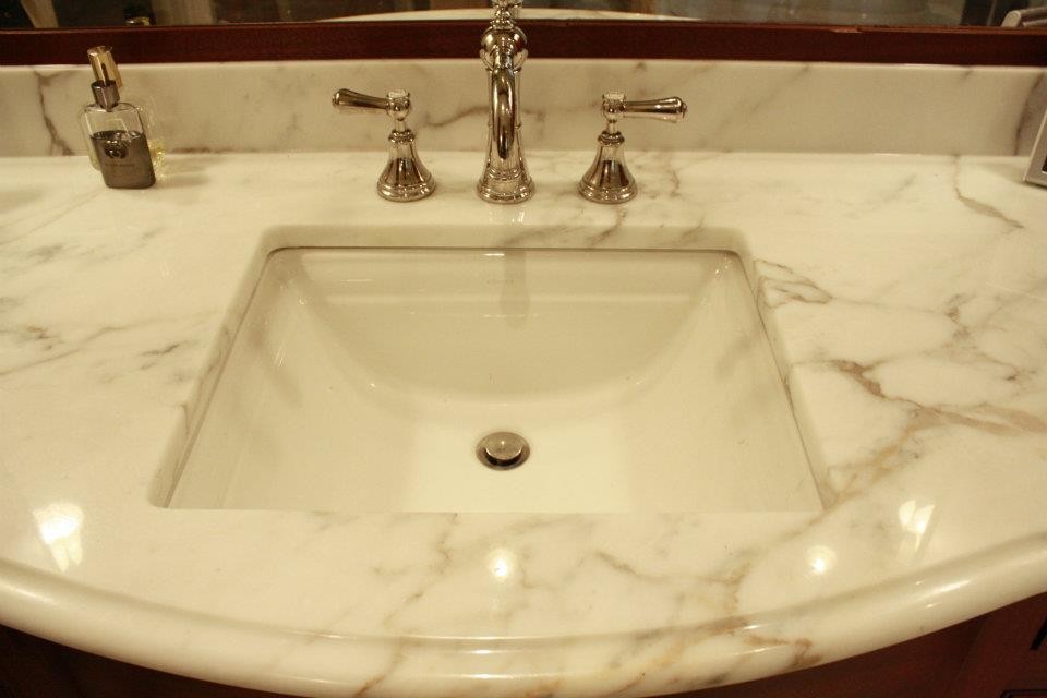 Idée de décoration pour une très grande salle de bain principale tradition avec un lavabo encastré et un plan de toilette en marbre.
