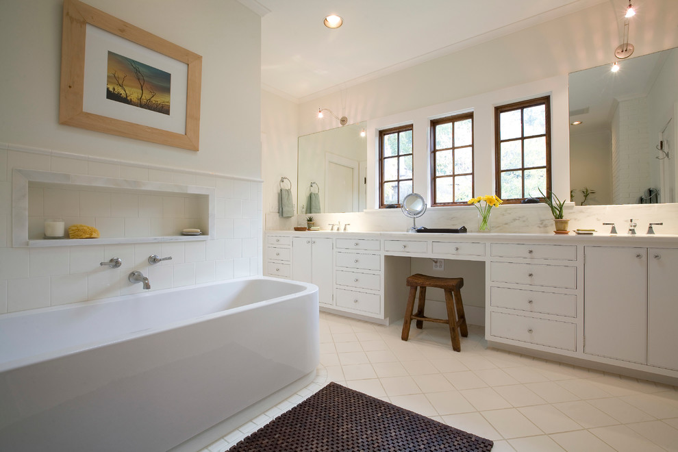 Classic bathroom in Birmingham with white cabinets, a freestanding bath and beige walls.