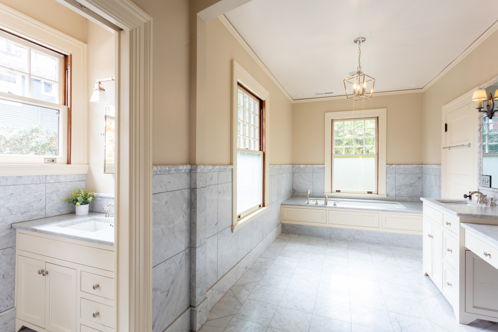 This is an example of a large traditional ensuite bathroom in Portland with recessed-panel cabinets, white cabinets, a built-in bath, grey tiles, marble tiles, beige walls, marble flooring, marble worktops, grey floors, grey worktops, double sinks and a built in vanity unit.