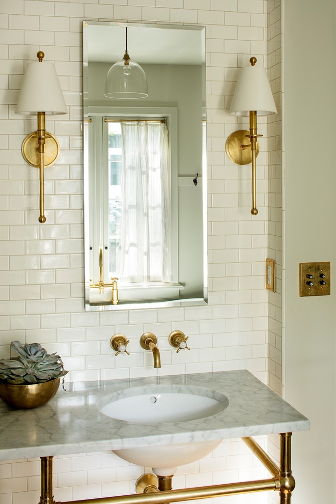 Inspiration pour une salle de bain principale traditionnelle de taille moyenne avec une baignoire indépendante, un carrelage blanc, un carrelage métro, un mur gris, parquet foncé, un lavabo encastré, un plan de toilette en marbre et un sol marron.