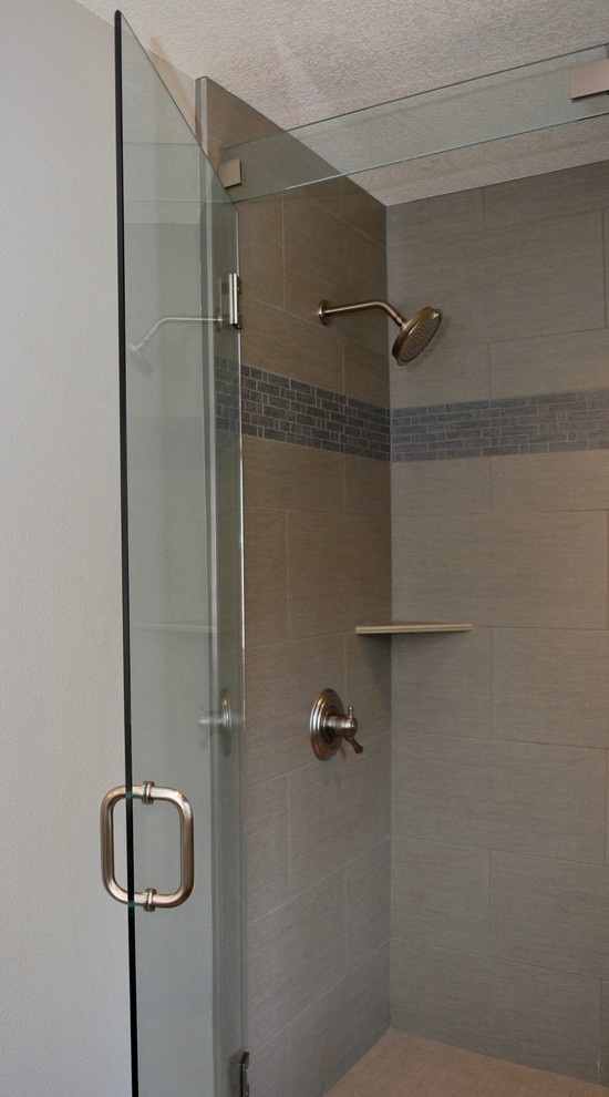 Стильный дизайн: главная ванная комната среднего размера в стиле неоклассика (современная классика) с фасадами в стиле шейкер, серыми фасадами, отдельно стоящей ванной, душем в нише, серой плиткой, плиткой мозаикой, бежевыми стенами, полом из керамогранита, врезной раковиной, столешницей из известняка, черным полом и душем с распашными дверями - последний тренд