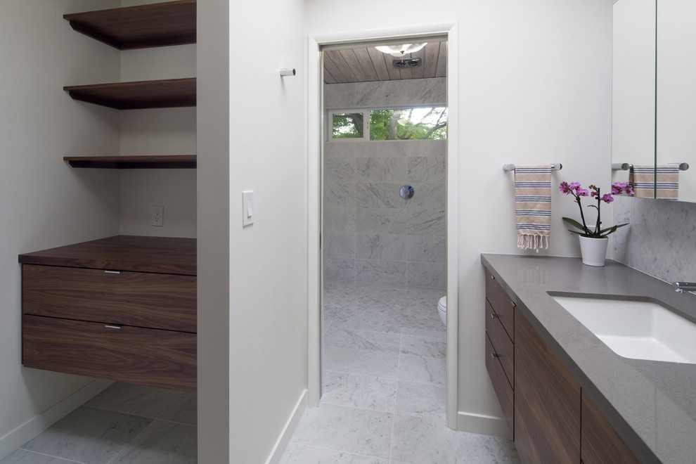 Design ideas for a medium sized retro ensuite bathroom in Portland with flat-panel cabinets, medium wood cabinets, a built-in shower, a one-piece toilet, multi-coloured tiles, marble tiles, white walls, marble flooring, a submerged sink, solid surface worktops, multi-coloured floors, an open shower and grey worktops.