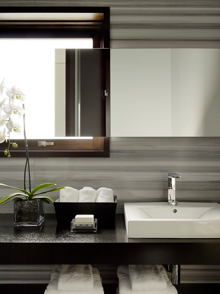 Foto de cuarto de baño contemporáneo con encimera de granito, baldosas y/o azulejos grises, losas de piedra y suelo de madera en tonos medios