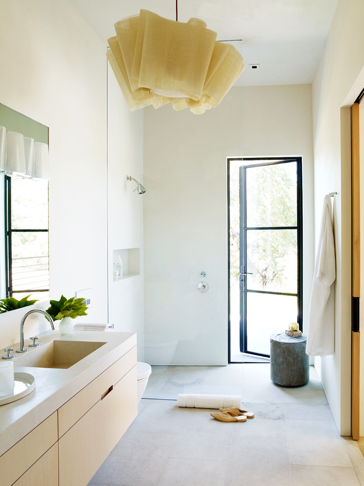 Idéer för att renovera ett funkis badrum med dusch, med släta luckor, skåp i ljust trä, en öppen dusch, vita väggar, ett integrerad handfat, beiget golv och med dusch som är öppen