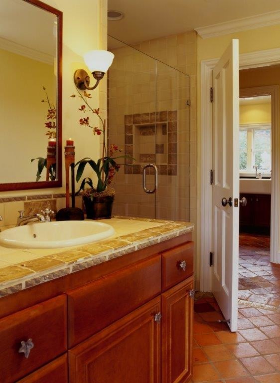 Exempel på ett mellanstort rustikt badrum med dusch, med skåp i mellenmörkt trä, kaklad bänkskiva, en hörndusch och klinkergolv i terrakotta